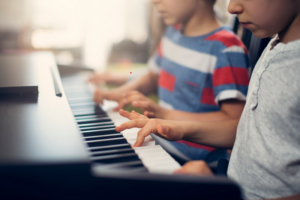 Kinder spielen vierhändig Klavier